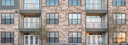 Daytime exterior video of AMLI Covered Bridge building multicolored brick façade including windows and balconies