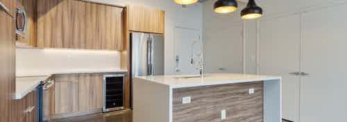 Redesigned interior of AMLI on 2nd kitchen with modern multi toned wooden cabinets and stainless steel appliances