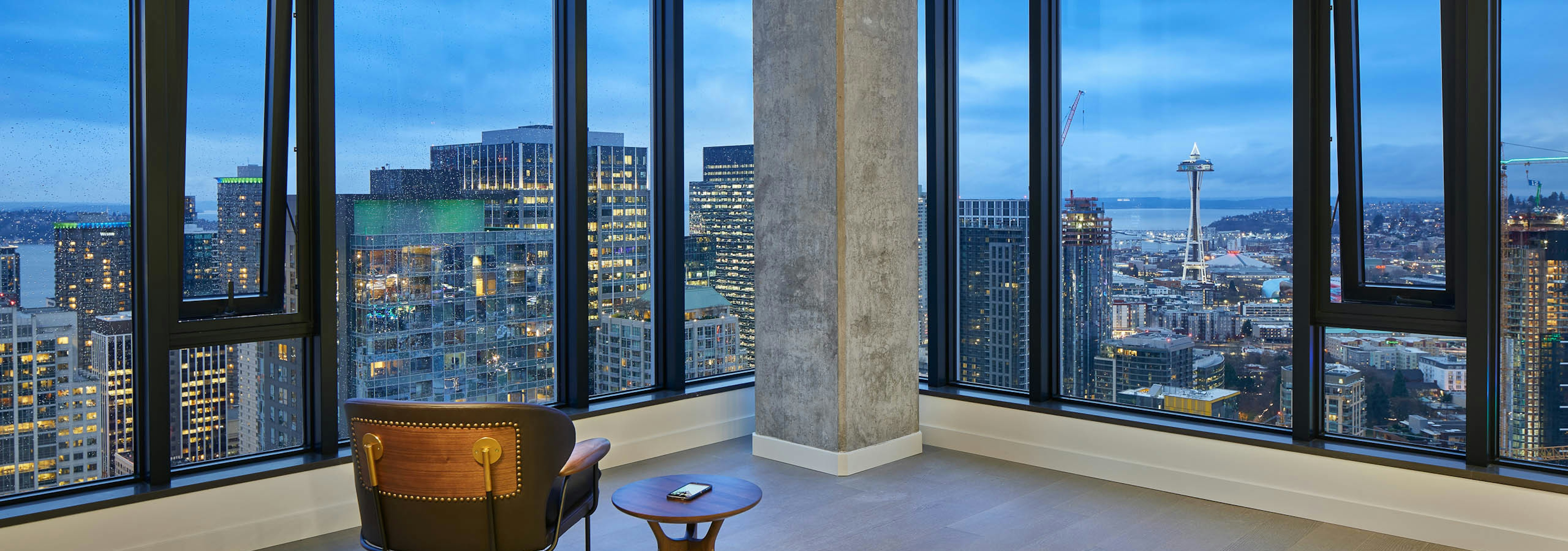 Interior view of apartment of AMLI Arc penthouse living room with floor to ceiling windows and view of Downtown Seattle 