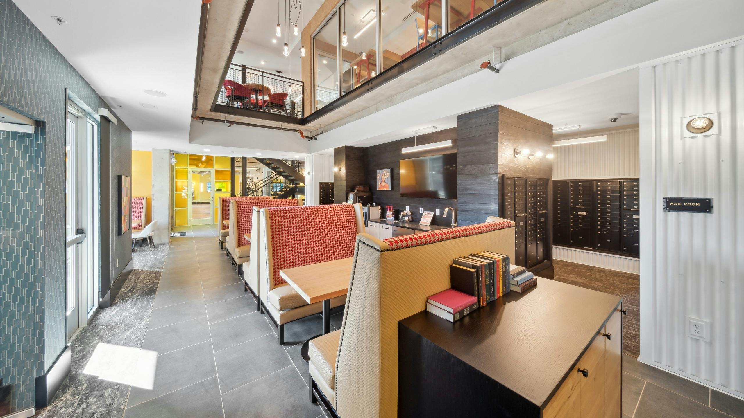 Coworking space at AMLI RiNo with glass window to second floor overlooking banquet seating with wet bar and mailroom
