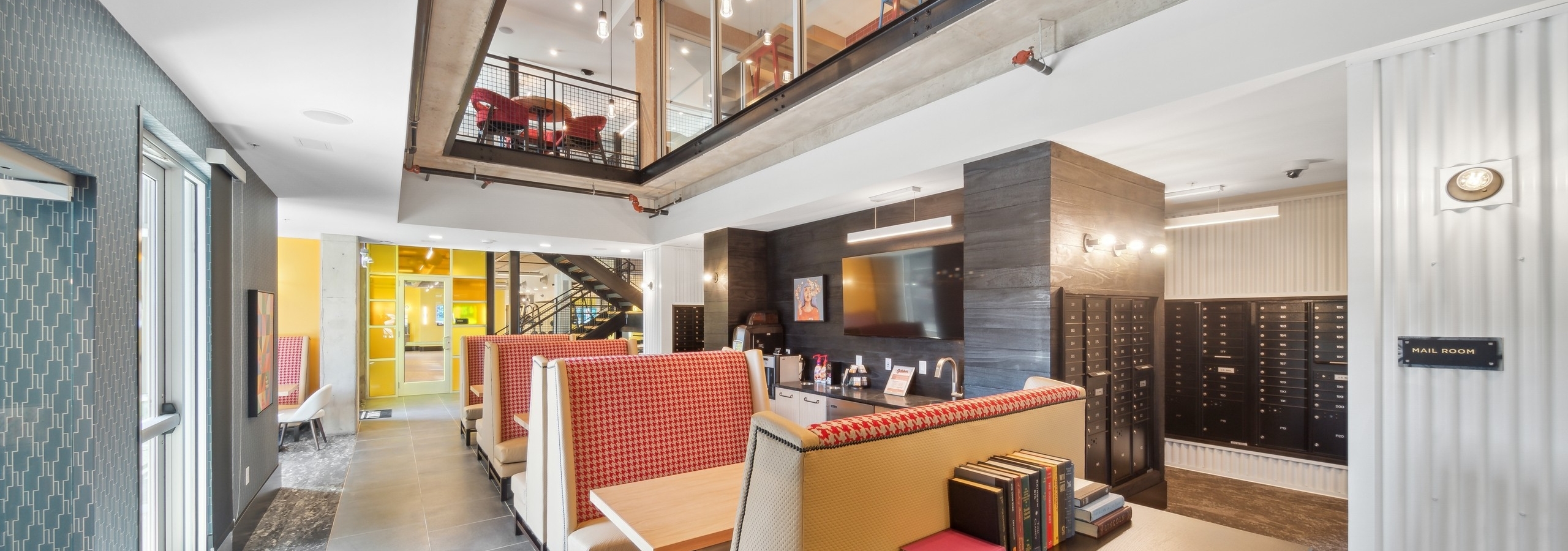 Coworking space at AMLI RiNo with glass window to second floor overlooking banquet seating with wet bar and mailroom