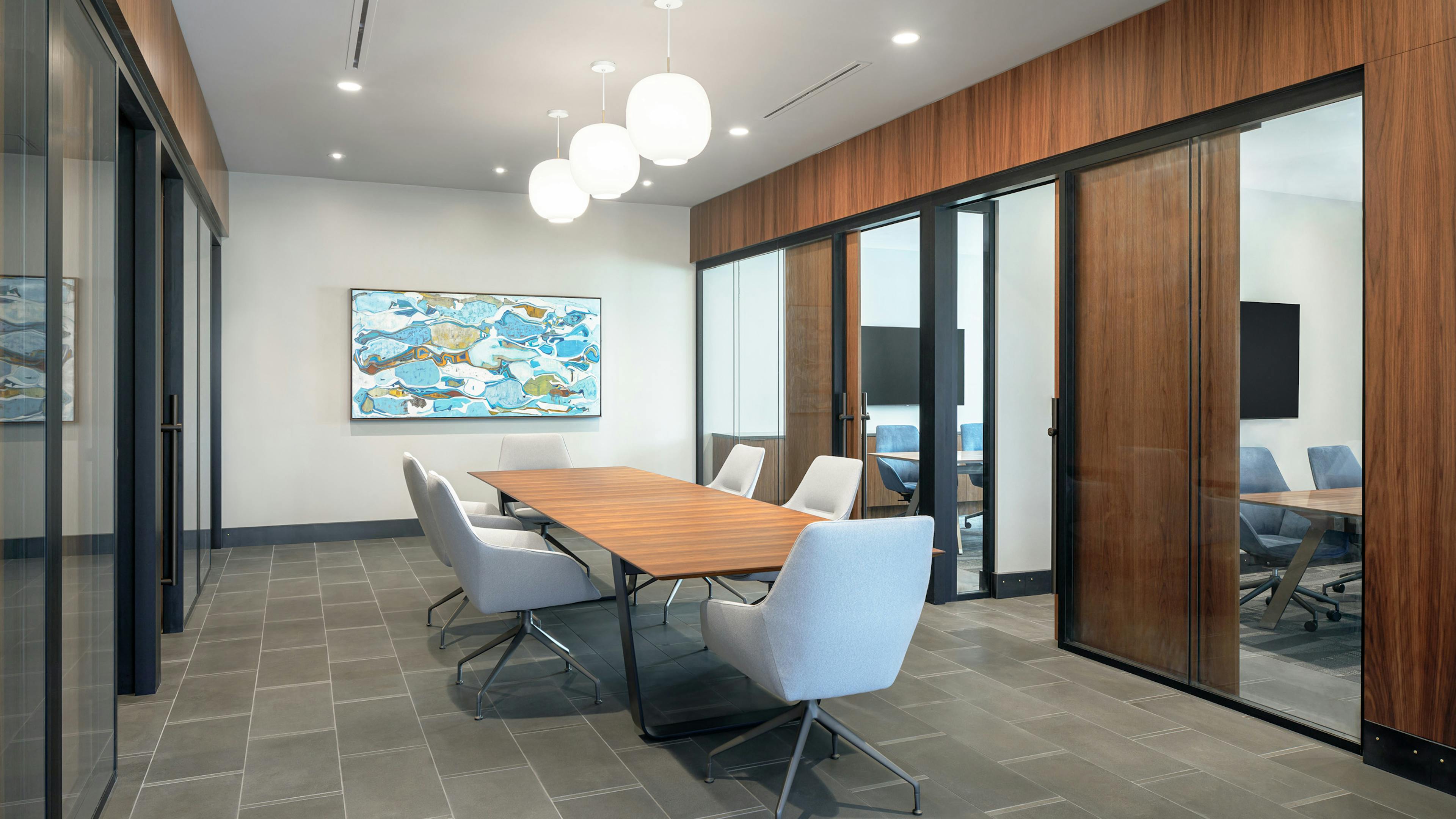 Interior view of AMLI Fountain Place conference room with table and 6 chairs surrounded by private offices with glass walls