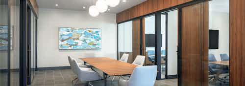 Interior view of AMLI Fountain Place conference room with table and 6 chairs surrounded by private offices with glass walls