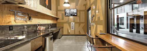 Interior of cooking lab for beer making at AMLI South Lake Union high wooden wall ceilings sink and stove and tv on wall