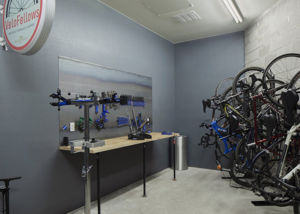 Interior bike repair room area at AMLI Riverfront Green apartments with view of work station table with tools and bike racks
