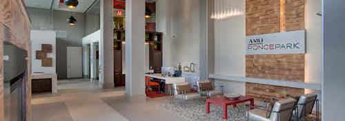 Interior of leasing office at AMLI Ponce Park with high ceilings and multiple desks with seating area and a coffee bar