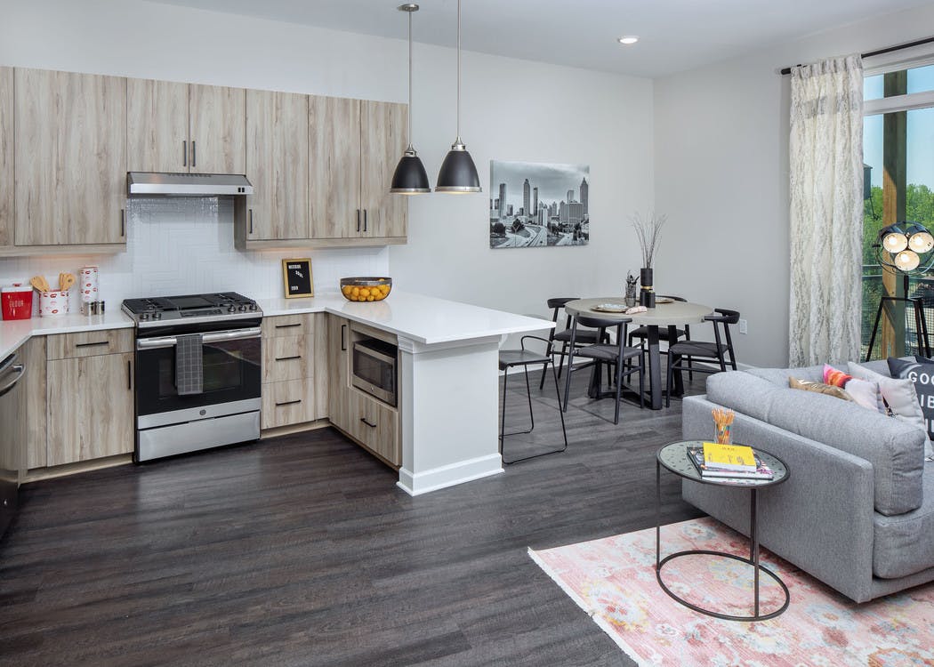 AMLI Westside apartment kitchen with light wooden cabinets and stainless steel appliances with white countertops