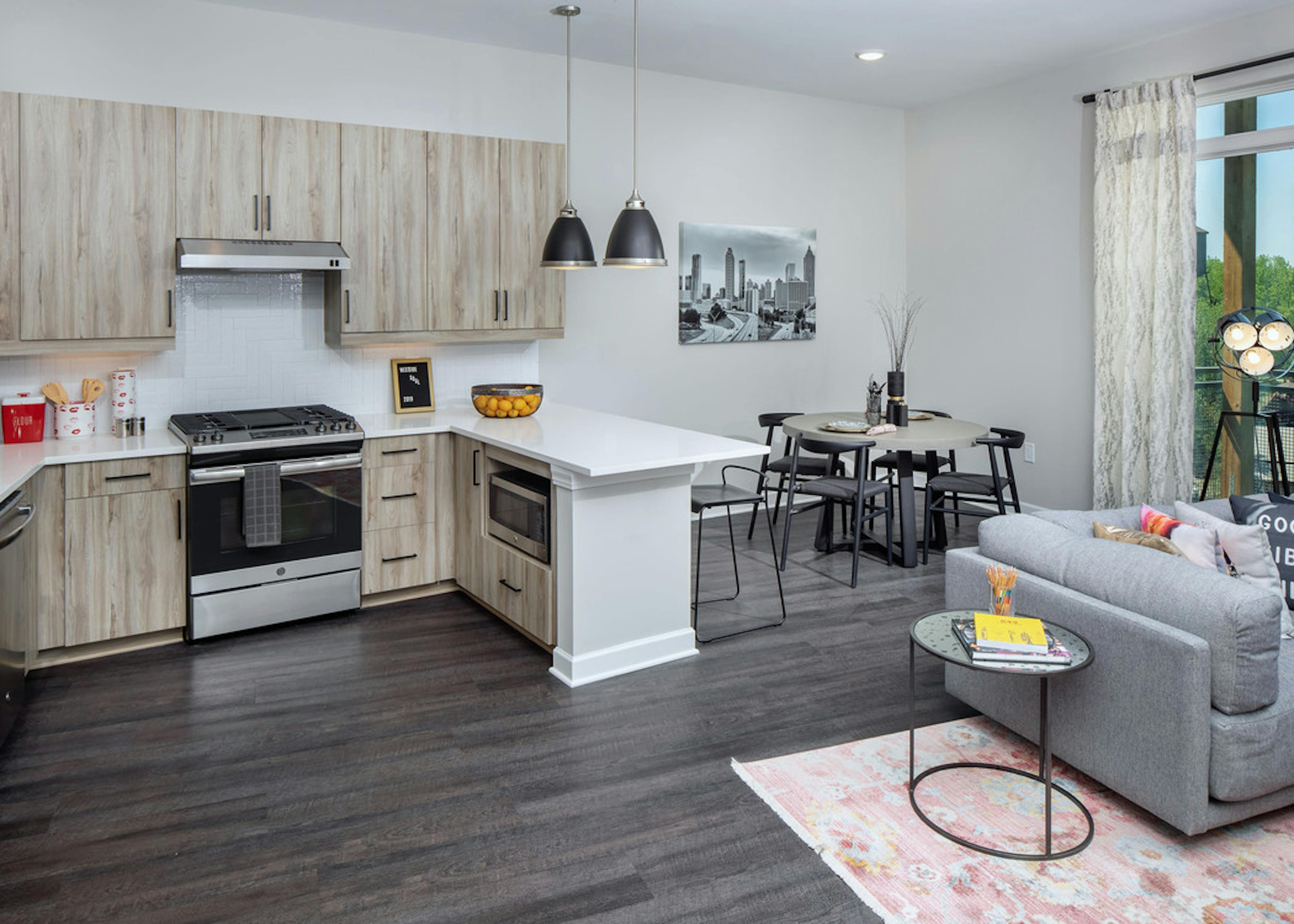 AMLI Westside apartment kitchen with light wooden cabinets and stainless steel appliances with white countertops