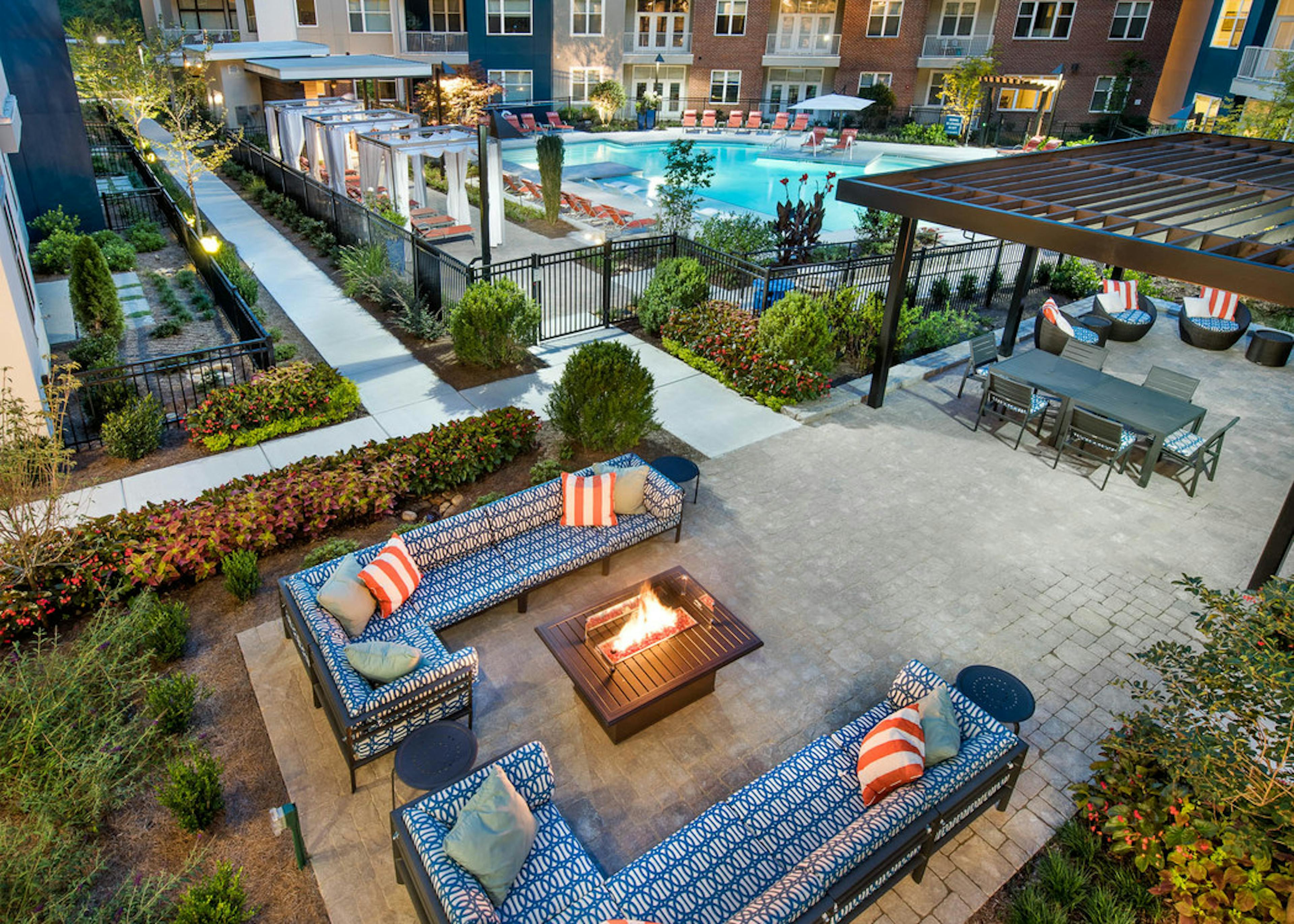 Ariel view of two blue L couches with a fire pit in the center and green foliage surrounding the patio area at AMLI Buckhead
