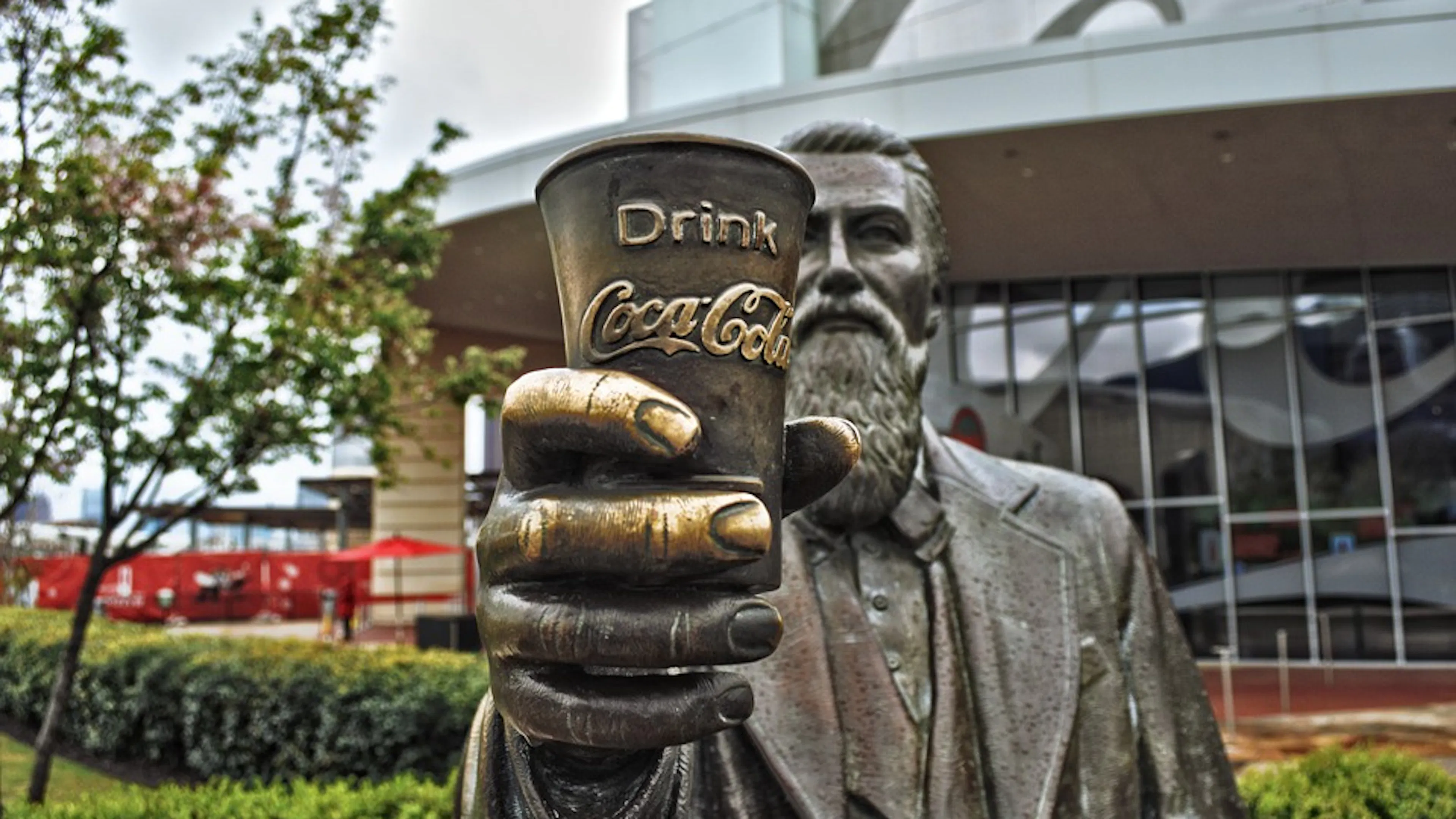 The statue of John Pemberton inventor of Coca Cola holding a cup of Coke