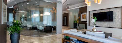 AMLI River Oaks lobby and HDTV living room with couch seating and bookshelves and glass enclosed leasing office in back