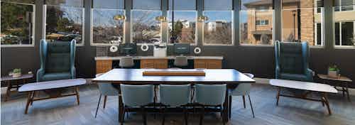 Business center at AMLI Inverness apartments with conference table and chairs and coffee tables as well as several windows