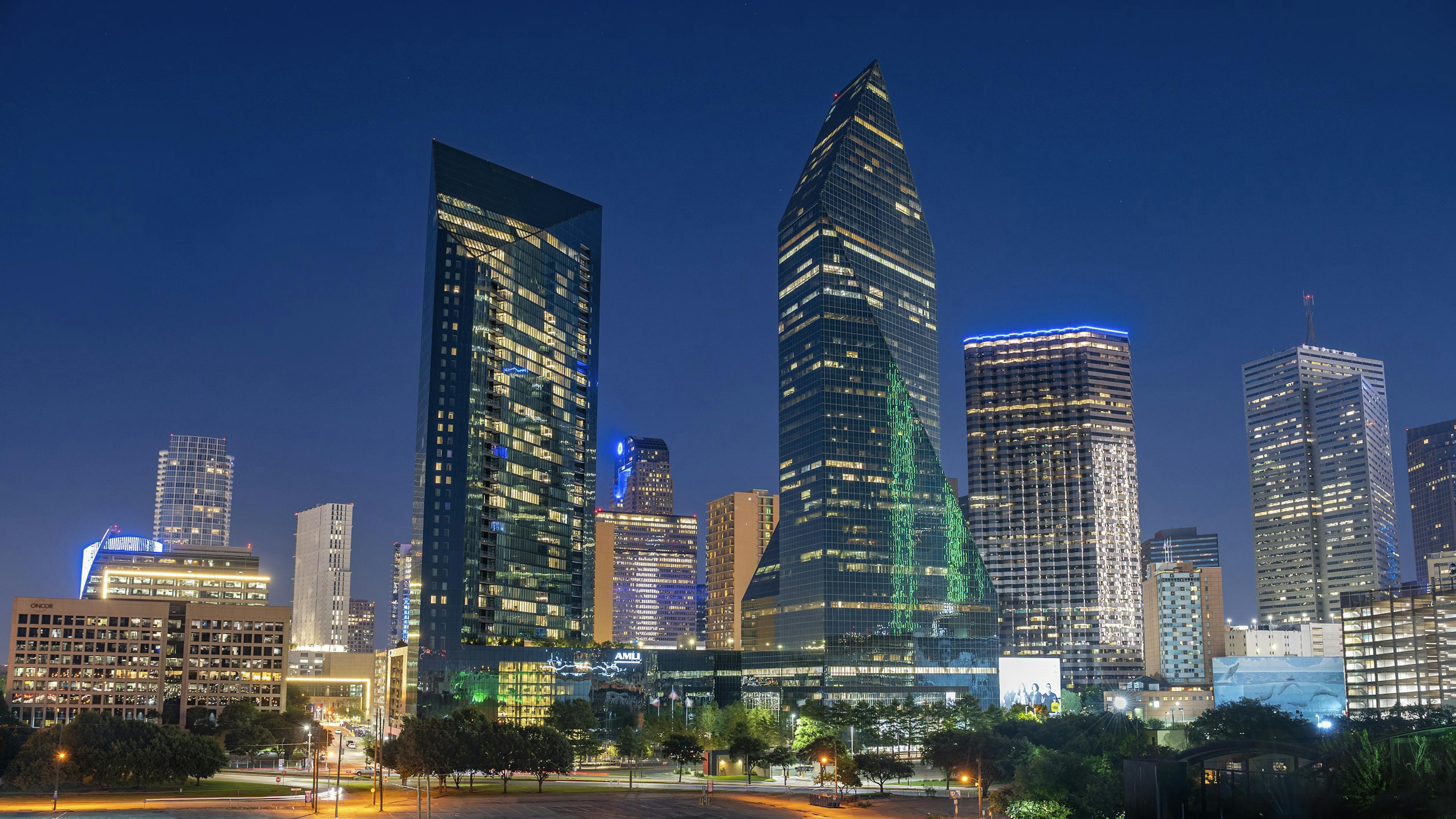 Nighttime exterior view of AMLI Fountain Place apartment building and Fountain Place corporate office building