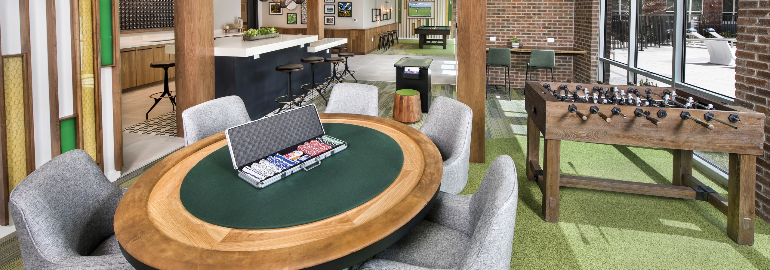 AMLI Decatur clubroom with a poker table and foosball with an arcade game as well as billiards and a serving kitchen