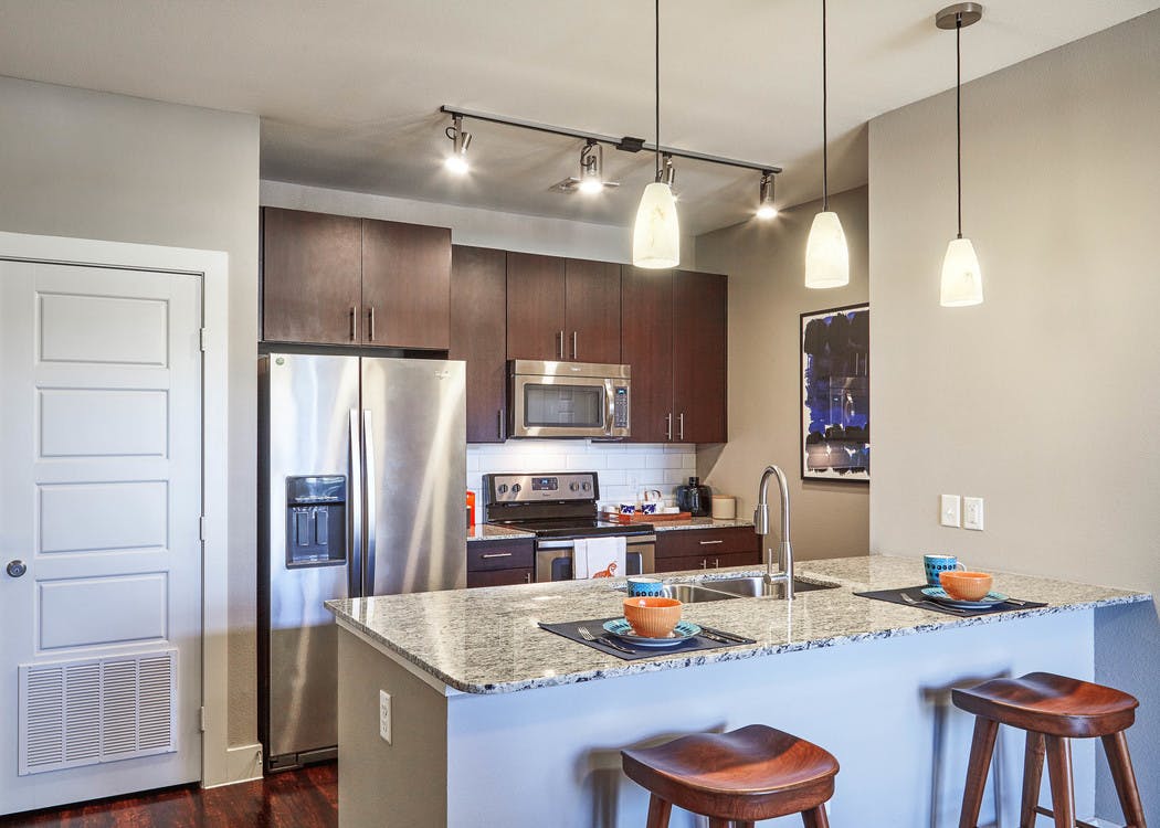 AMLI Covered Bridge gourmet kitchen with light walls, stainless steel appliances and under mount extra deep stainless sink