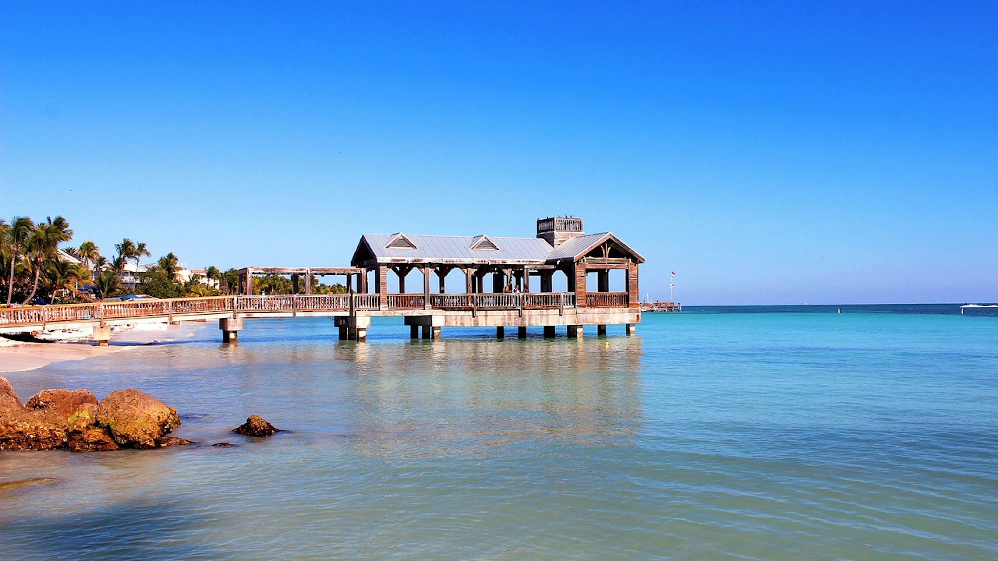 A wooden dock over still calm ocean waters in the Florida Keys