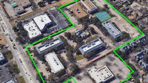Aerial view of land purchased for AMLI Tree House apartments with buildings and a bright green outline showing parcel