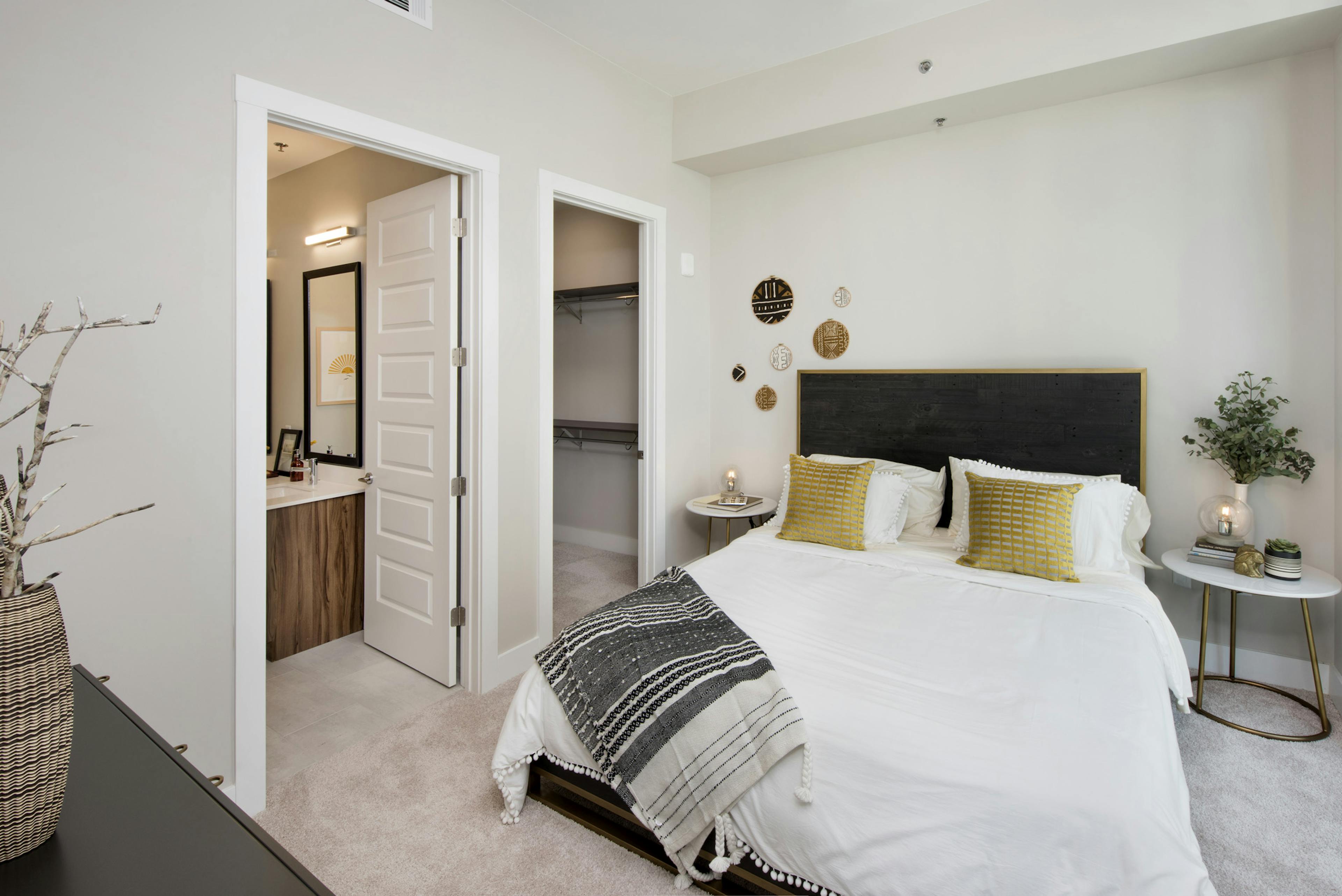 AMLI Lenox bedroom with floor to ceiling window and a bed with a white comforter and bedside nightstands and walk in closet