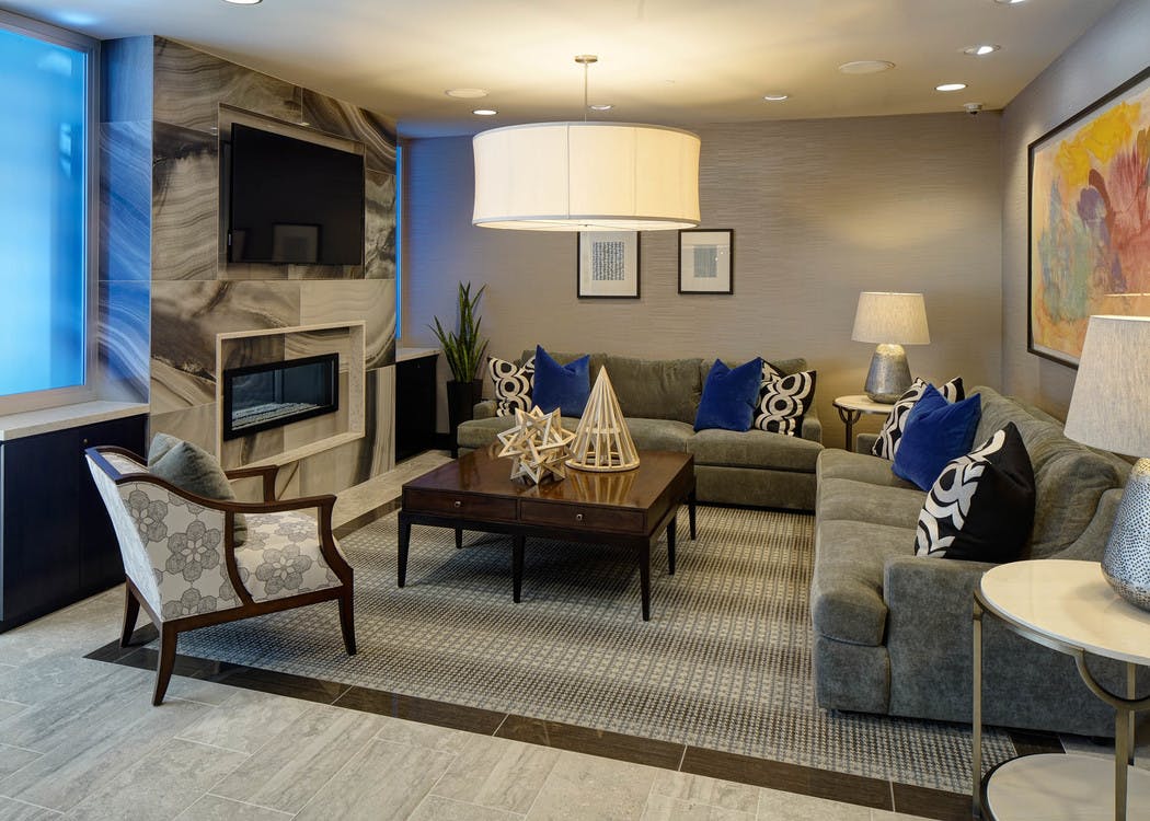 Resident lounge at AMLI Deerfield with a marble fireplace and large TV with various couch and chair seating options