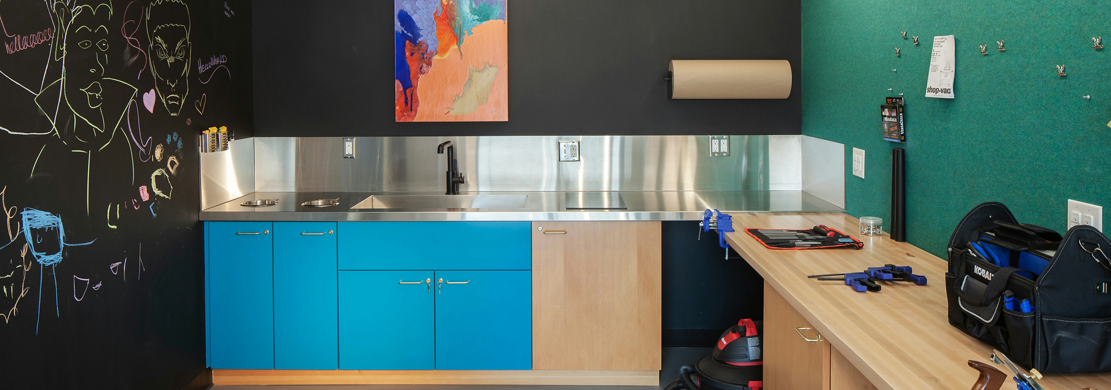 A DIY Maker Room at AMLI Riverfront Green apartments with work table and tool box as well as a large sink area with cabinets