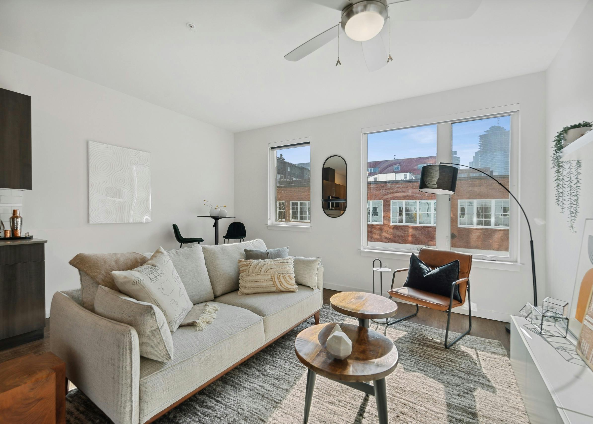 Interior view of a living room at AMLI South Lake Union apartments with a couch and coffee tables and windows with city views