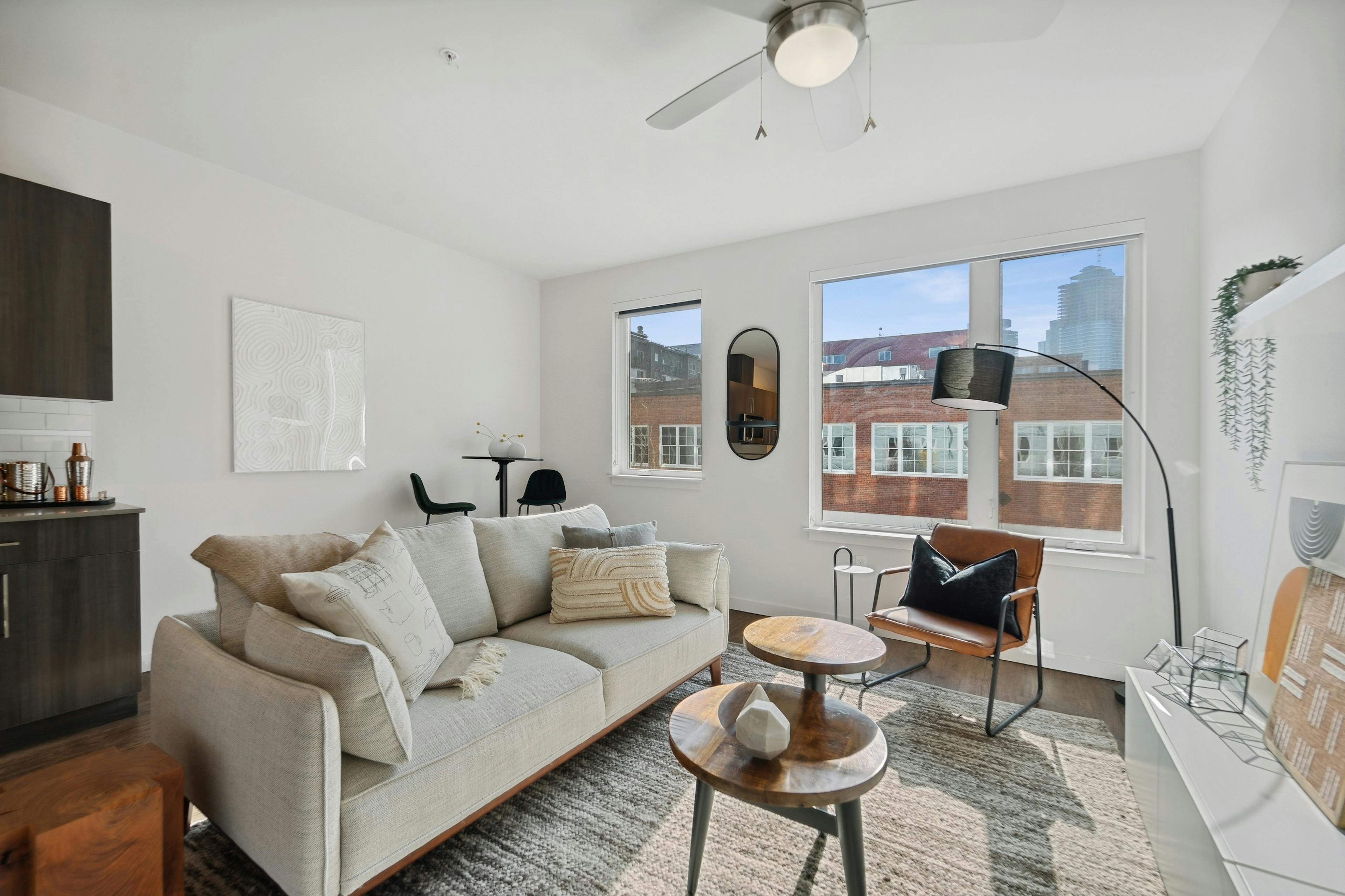 Interior view of a living room at AMLI South Lake Union apartments with a couch and coffee tables and windows with city views