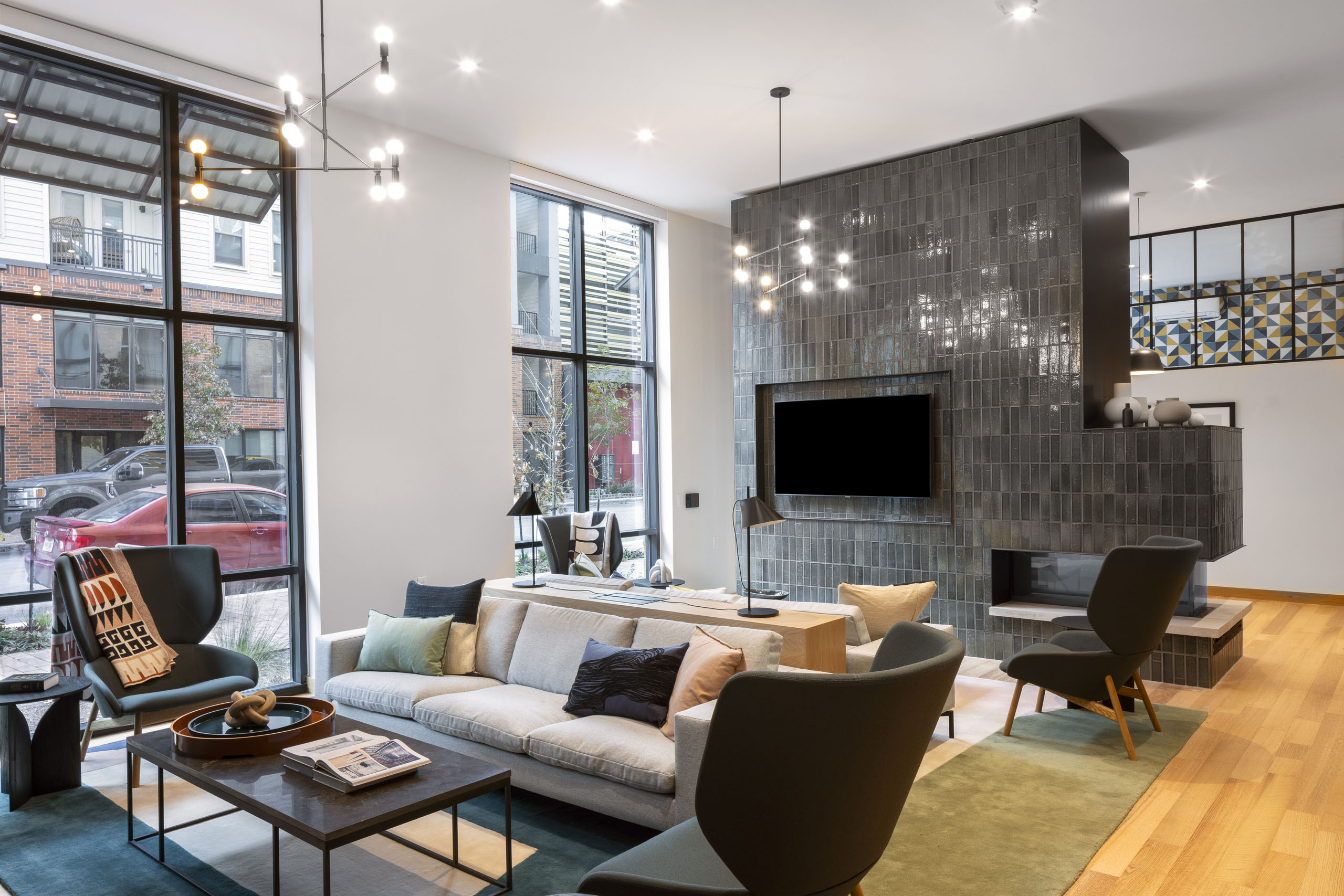 AMLI Branch Park coworking space with floor to ceiling windows and green tiled fireplace with a large television