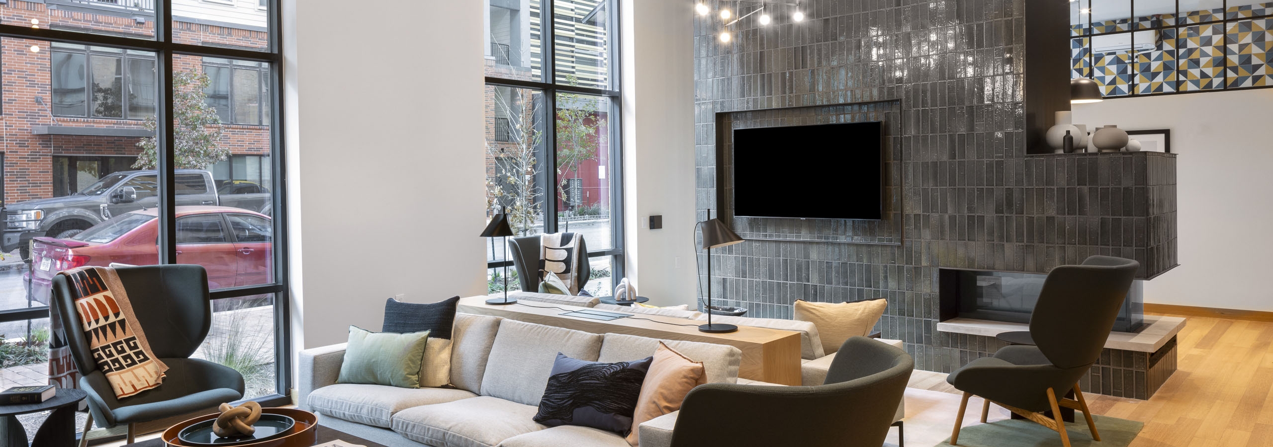 AMLI Branch Park coworking space with floor to ceiling windows and green tiled fireplace with a large television