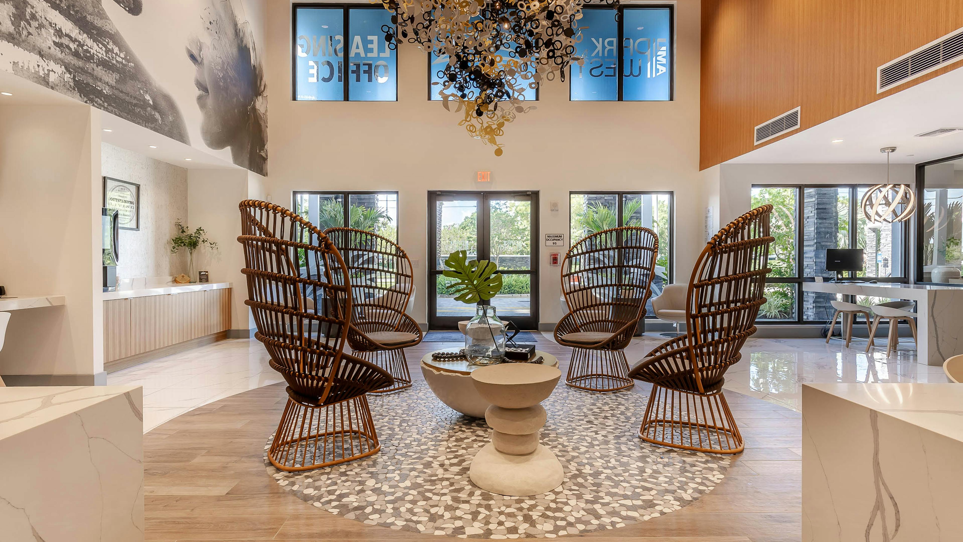 The lobby at AMLI Park West apartments with rattan armchairs and round coffee table with O shaped chandelier and wall mural 