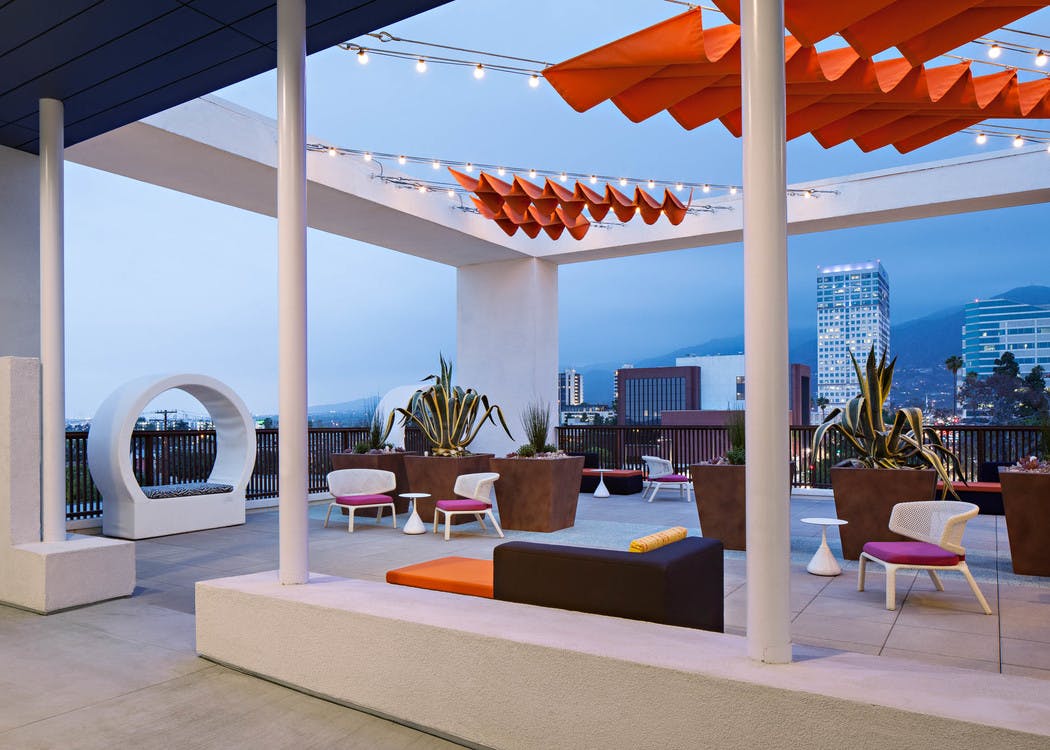 Exterior view of Sky deck overlooking the city lights at dusk with various lounge seating at AMLI Lex on Orange apartments