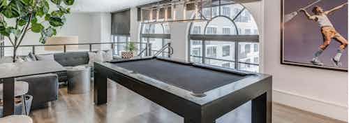 Second floor interior view of the AMLI Joya two story game room with billiards table and artwork of tennis player