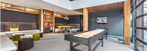 Endless amounts of entertainment in our resident lounge at AMLI Wallingford shuffleboard television and an open air area into the courtyard
