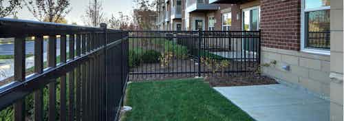 Exterior view of first floor private fenced in patio and lawn in the daytime light at AMLI Deerfield apartment community