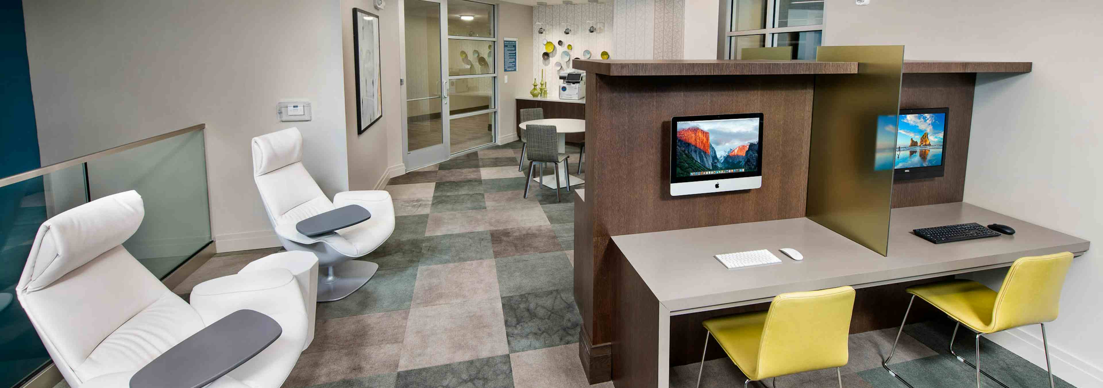 AMLI Buckhead business center with two desks with yellow chairs and a computer for each and two white node office chairs