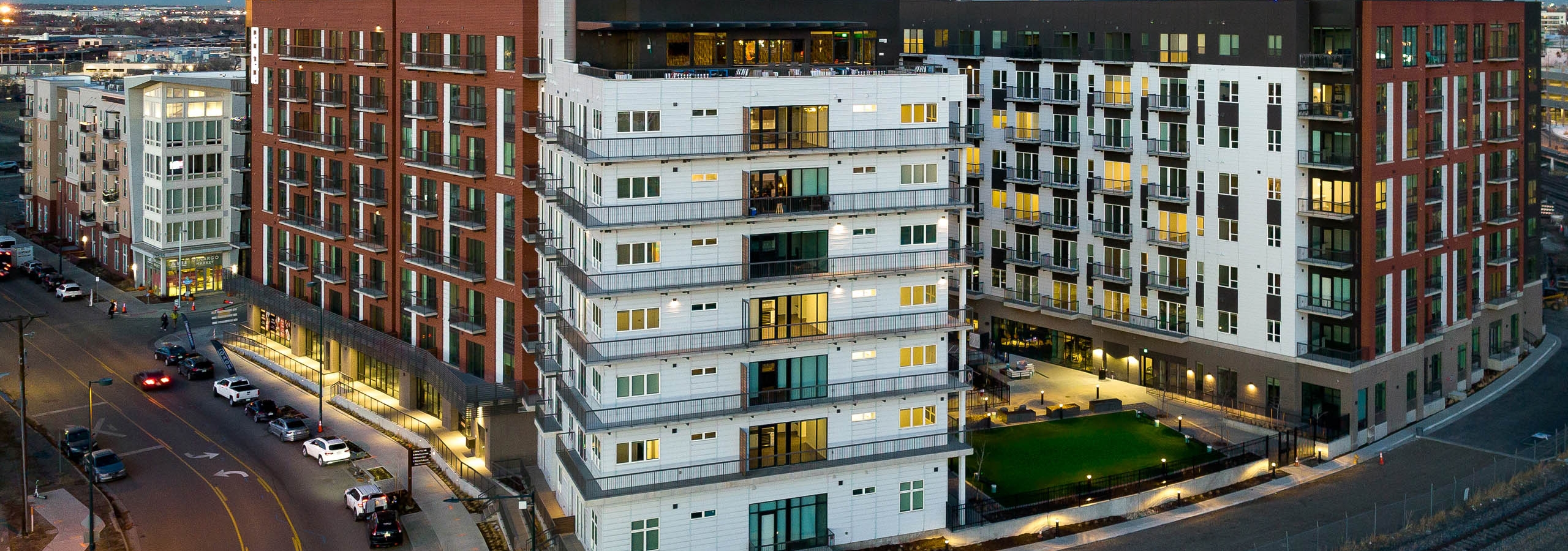 Evening aerial of the AMLI Art District apartment building with view of sky lounge and balconies and cars on the street
