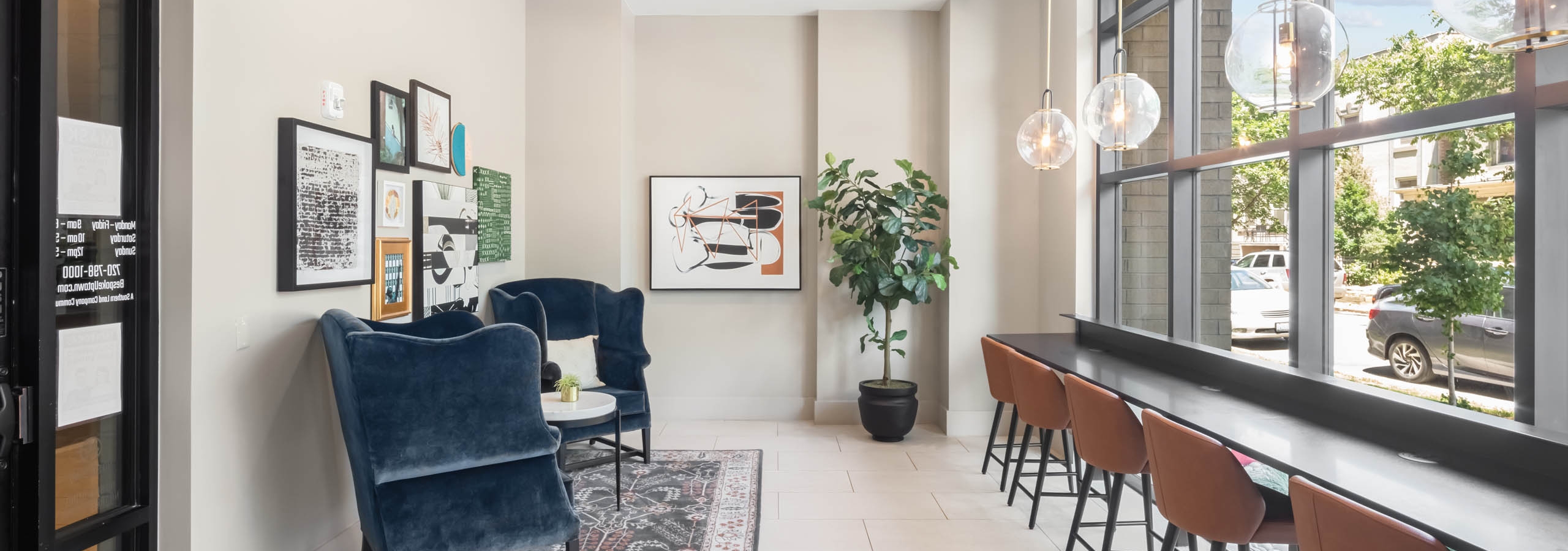 AMLI at Uptown ride share lounge with velvet chairs and leather stools at a sleek counter running against floor to ceiling windows