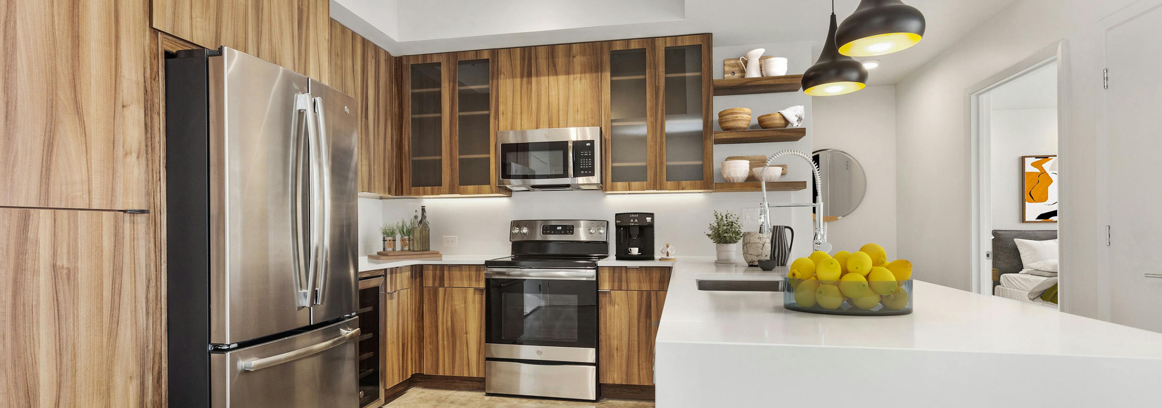 View of kitchen at AMLI on 2nd with concrete flooring and wood cabinets and stainless steel appliances with white countertops