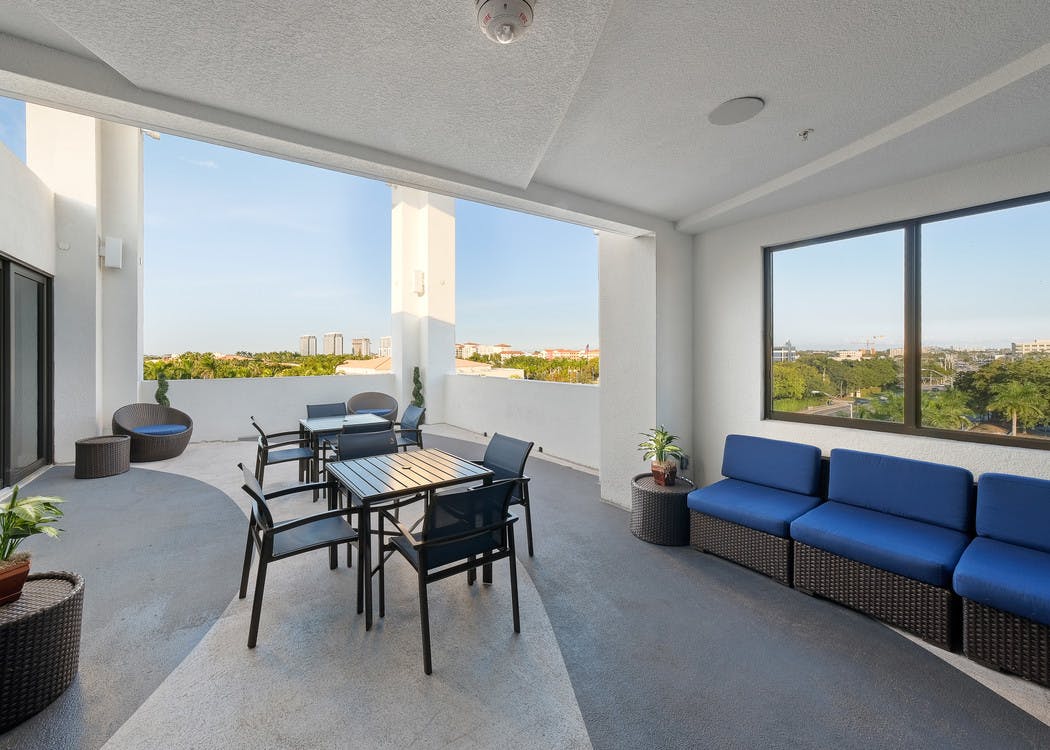 AMLI 8800 exterior skyline view of the rooftop terrace with table and chairs and blue sofa seating area