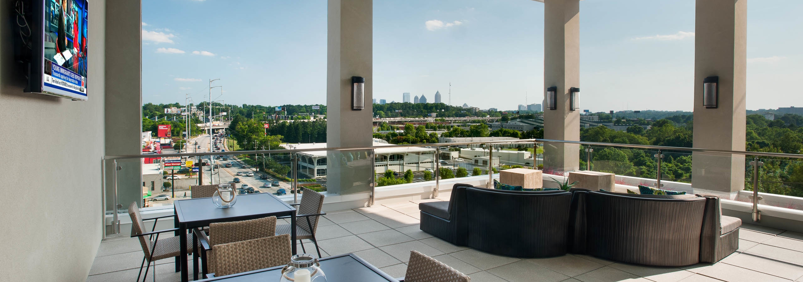 Daytime exterior view of AMLI Piedmont Heights sky deck with various seating areas overlooking Atlanta skyline