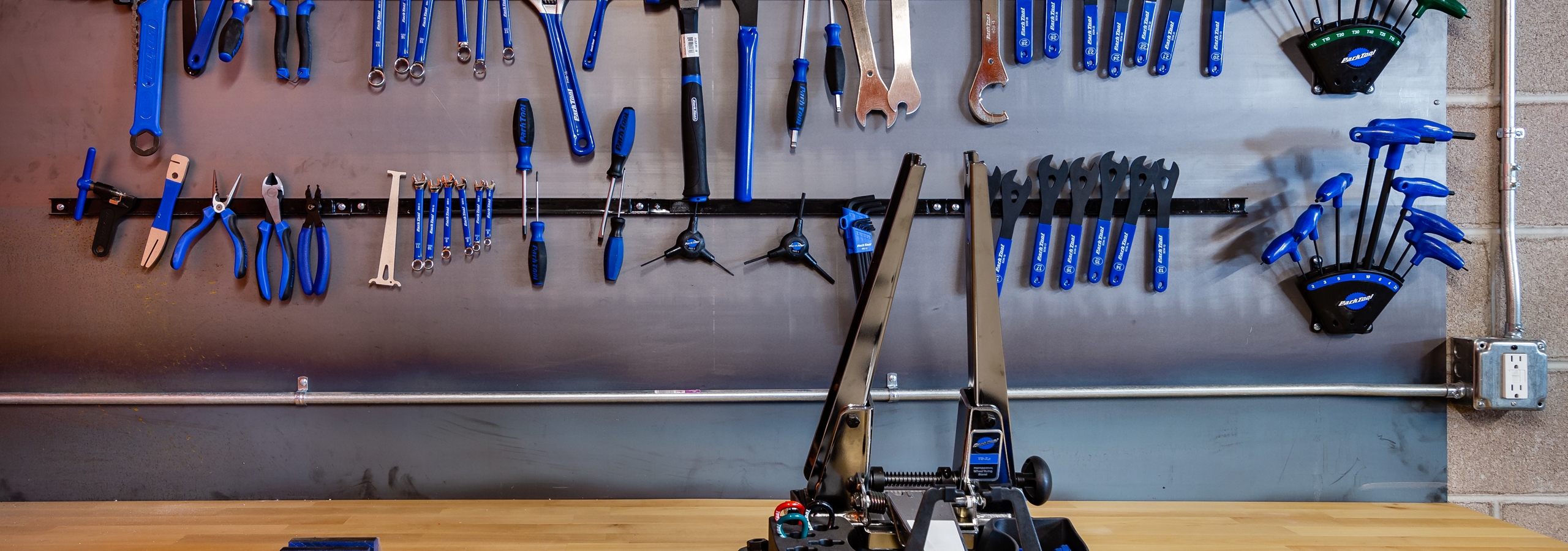 Bike/ski/snowboard repair room with magnetic tool bar holding an assortment of tools at AMLI Littleton Village apartments