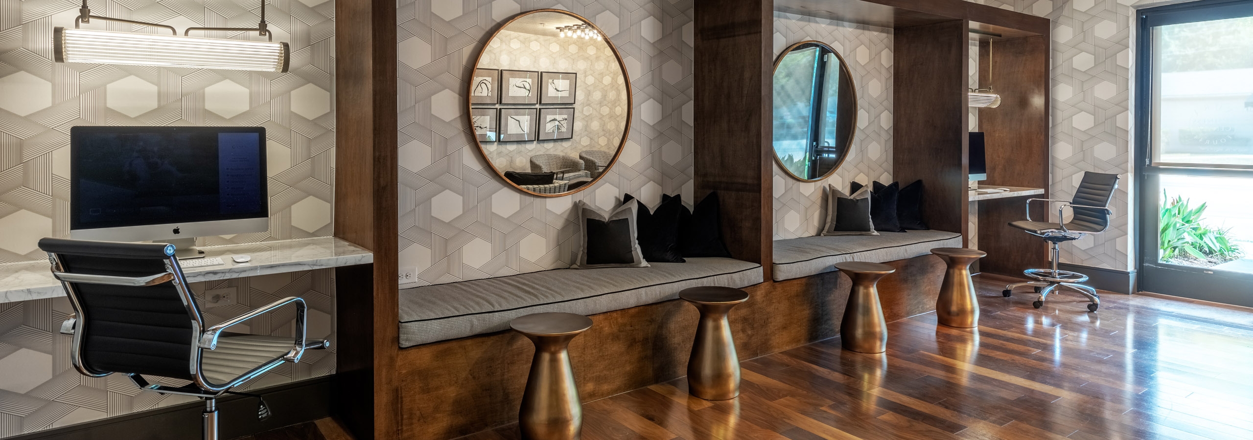 AMLI Grapevine business center with hardwood floors and two circular mirrors hung up against a geographic pattern wallpaper