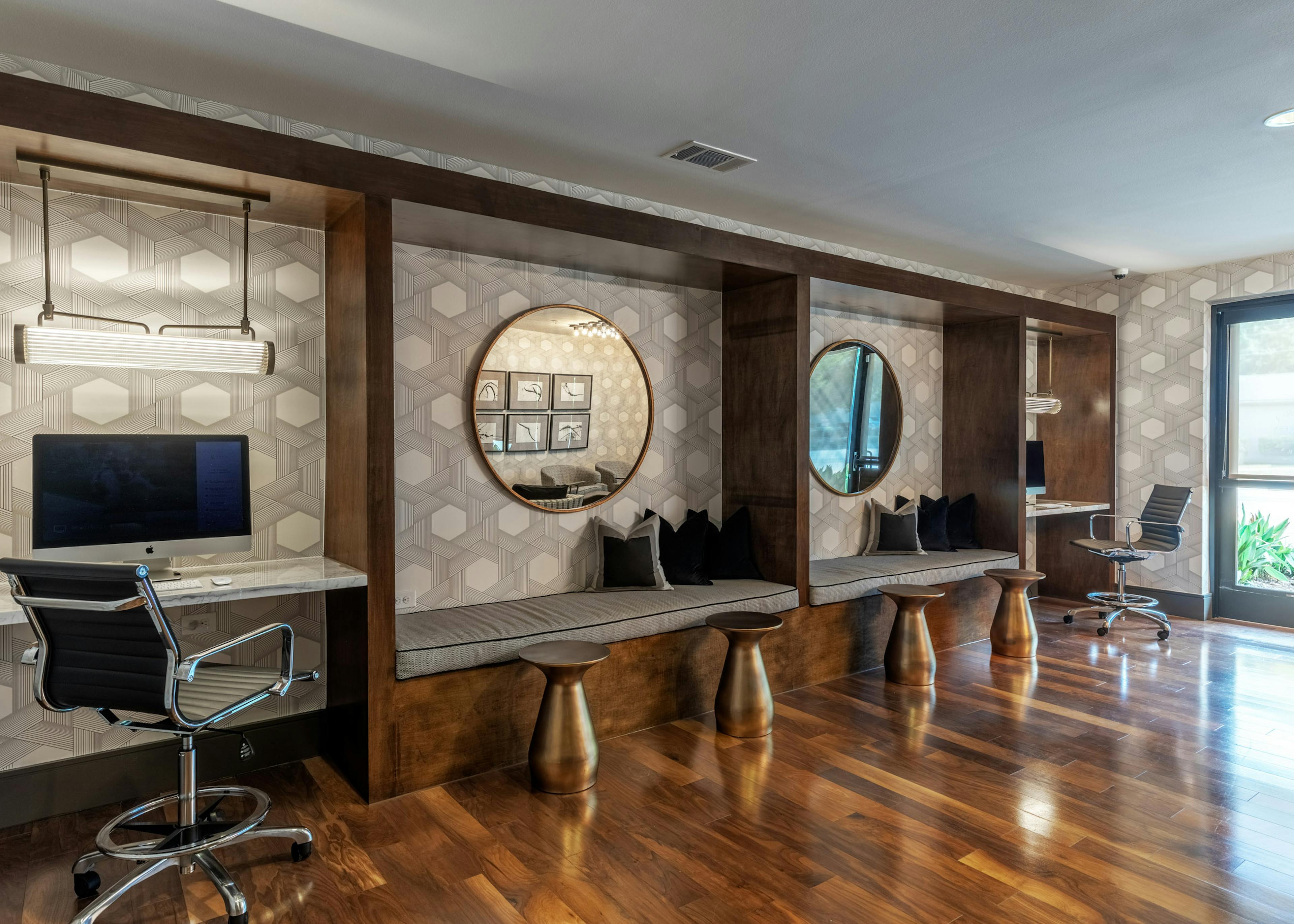 AMLI Grapevine business center with hardwood floors and two circular mirrors hung up against a geographic pattern wallpaper