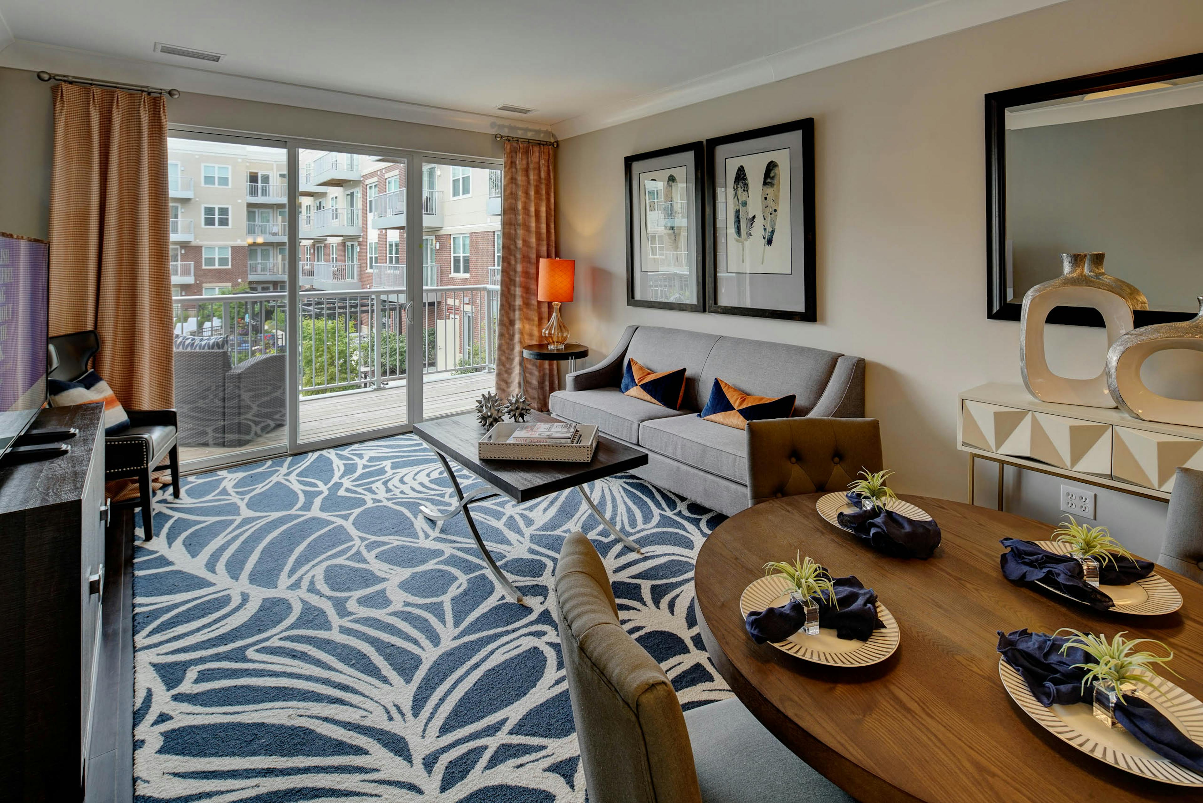 AMLI Deerfield living room with balcony overlooking courtyard view and furnished with couch and coffee table and décor