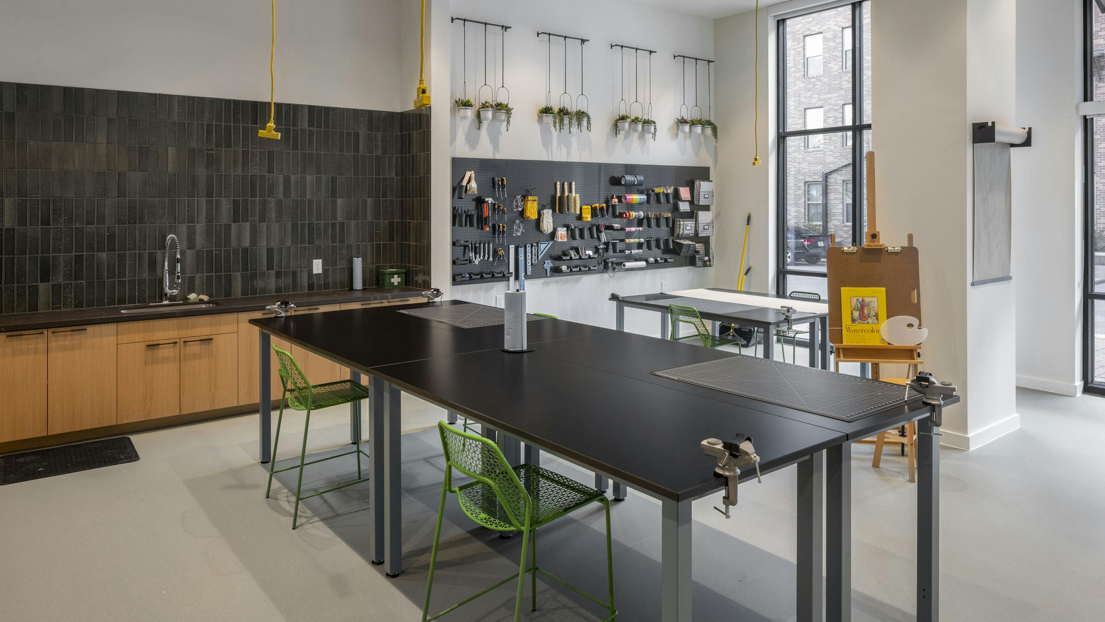 AMLI Branch Park apartments resident Maker Room with two large work tables and a variety of arts and crafts tools