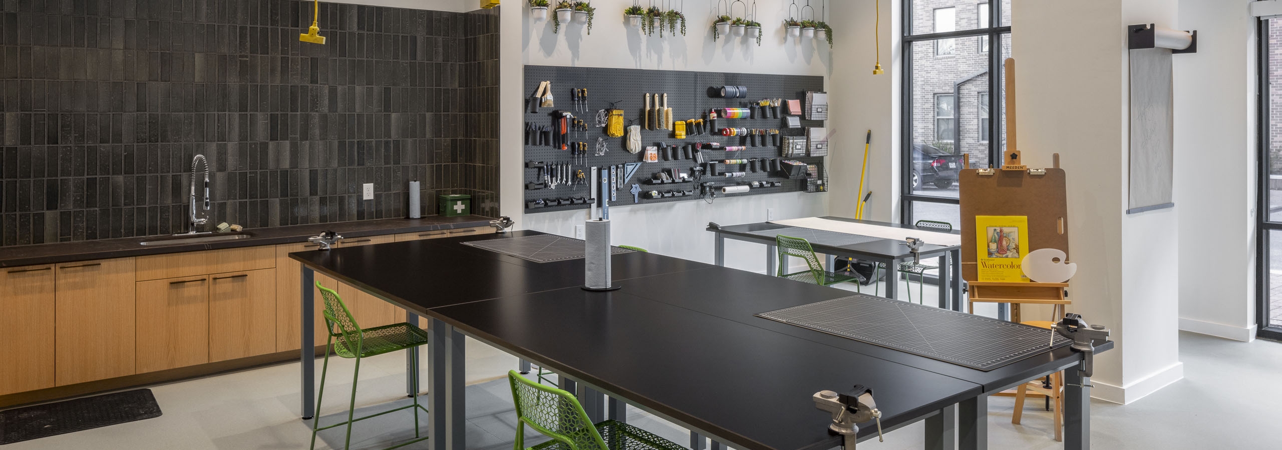 AMLI Branch Park apartments resident Maker Room with two large work tables and a variety of arts and crafts tools