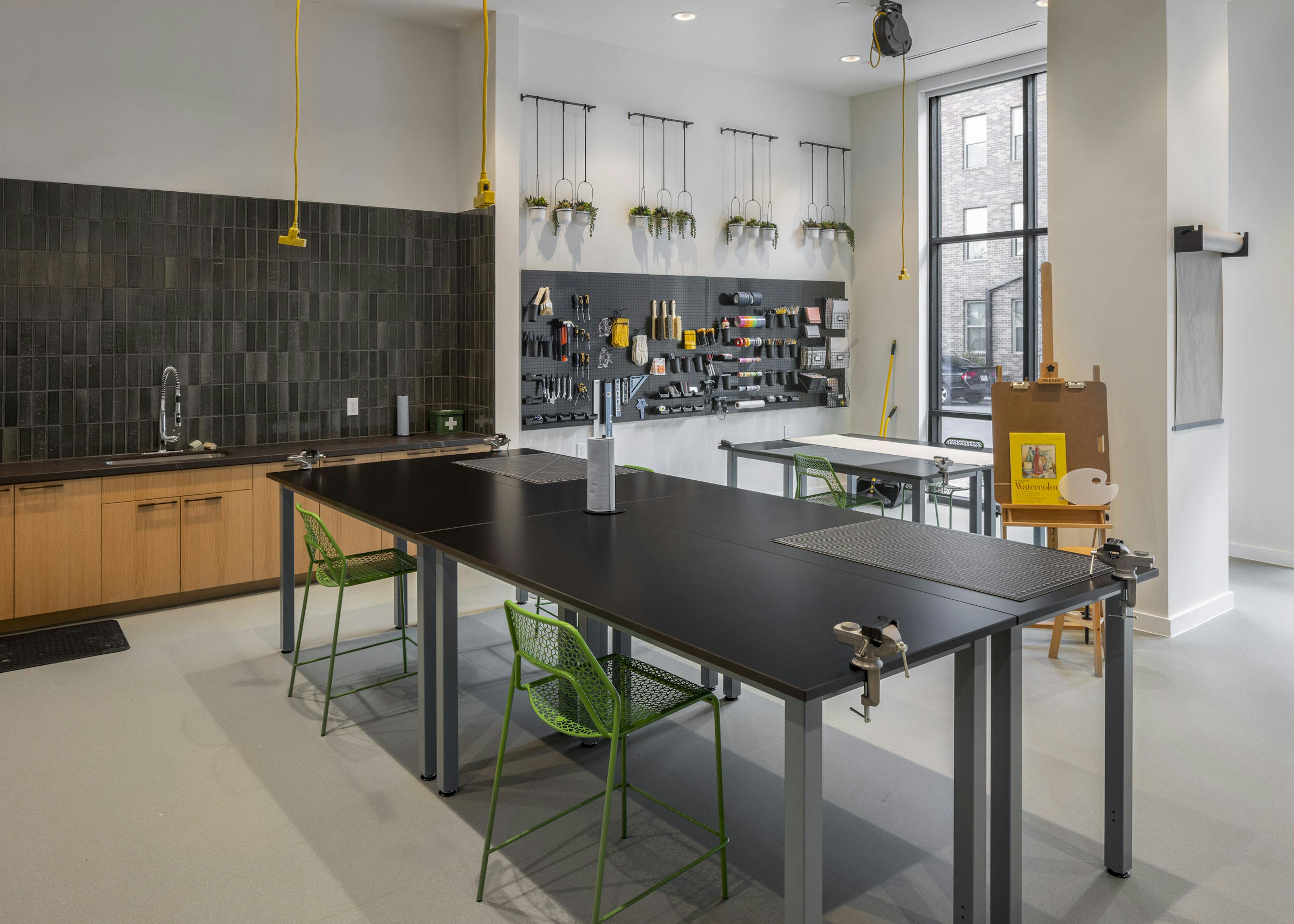 AMLI Branch Park apartments resident Maker Room with two large work tables and a variety of arts and crafts tools
