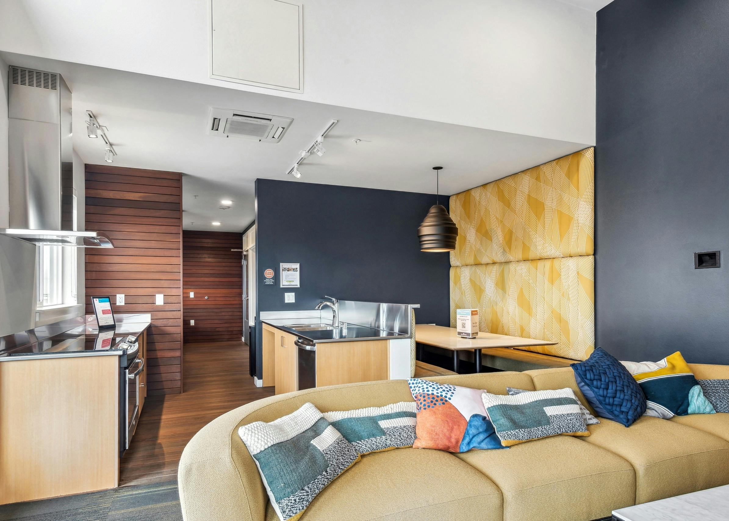 Interior view of a sky lounge at AMLI Wallingford with a couch in front of a kitchen area with stainless sink