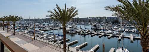 Daytime view of the walking promenade, marina and boat slips from an elevated lounge deck at AMLI Marina Del Rey apartments