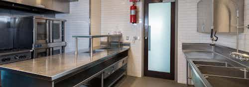 Interior of chef’s kitchen at AMLI Design District apartments with stainless steel professional-grade appliances
