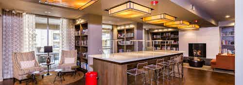 Interior of AMLI RidgeGate library with large top study desk, fireplace and various book cases overlooking the grand terrace